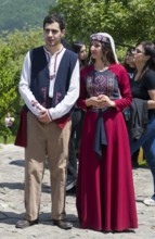 Two people in traditional clothes standing on a square in sunny weather, folklore, Tatev, Tatev,