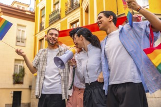 Group of happy young friends celebrating lgbtq plus pride, marching together in a city street with