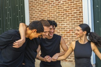 Diverse group of young adults laughing and embracing outdoors, enjoying casual summertime hangout