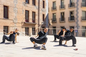 Group of diverse urban dancers concentrating on a synchronized performance, moving in dynamic poses