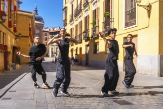 Four young dancers expressing themselves through contemporary dance, performing a street
