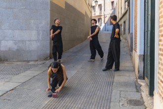 Group of young friends wearing black clothing rehearsing a contemporary dance routine on a