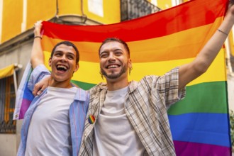 Happy young gay couple smiling, celebrating love, diversity, and lgbtq plus rights, holding a