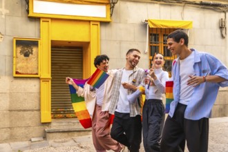 Young diverse friends celebrating lgbtqia plus pride, walking cheerfully on a city street, carrying