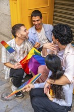 Diverse group of young adult friends enjoying a moment of connection outdoors, holding rainbow