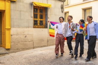 Happy queer friends celebrating lgbtq pride on a sunny historic cobblestone street in madrid,
