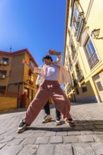 Young man actively dancing a contemporary urban street performance, expressing freedom and vibrant