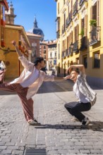 Two young men expressing emotion and movement through a modern dance routine on a cobblestone