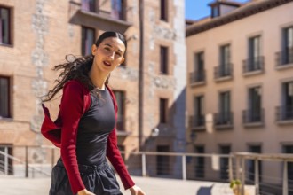 Hispanic young woman dancing with energy and spirit in an urban street, expressing freedom and joy