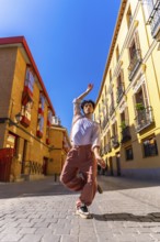 Young man creating art with his body, dancing ballet street style in an urban environment,