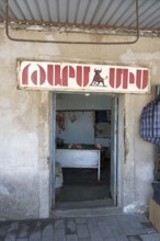 A butcher's shop with an open entrance and a sign above it, Martuni, Gegharkunik province, Armenia