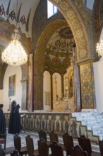 Monks pray in the magnificently decorated church with altar and chandelier, Inside the historic,