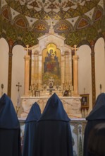 Monks pray in front of an ornately decorated altar with a religious icon, Inside the historic, most