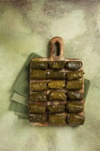 Dolma, minced meat with rice, in grape leaves, minced meat rolls, on a chopping board, top view, no