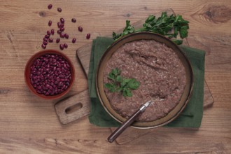 Red bean lobio, a traditional Georgian dish, on a wooden table, homemade