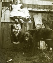 Boy and girl brother and sister playing with dog kennel in garden C 1900-1910, England, UK