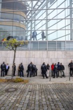 Men look out of the Konrad Adenauer House. Below, police detain activists of the New Generation.