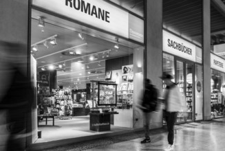 Black and white photograph, Dussmann GmbH, bookshop, urban scene in the evening with reflections in