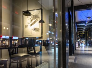 Urban scene in the evening with reflections of Friedrichstraße in the window pane of a bistro,