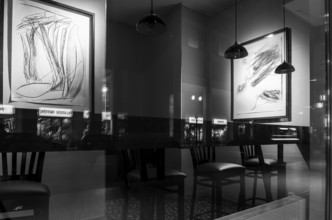 Black and white photograph, urban scene in the evening with reflections of Friedrichstraße in the