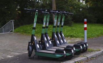 Several e-scooters, electric scooters, scooters parked on the pavement, pavement, in the Bolt bike