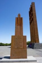 A tall red stone monument against a clear blue sky, Sardarapat Monument, Araks village, Armavir