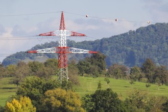 High-voltage pylon with signalling paint in front of the landscape of the Swabian Alb. Kirchheim