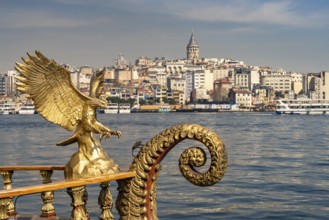 Golden oriental restaurant ship on the banks of Eminönü, Beyoglu and the Galata Tower, Istanbul,