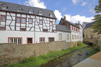 Historic half-timbered house Alte Mälzerei on the Erft stream and stone arch bridge, Bad