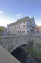 Heinz-Küpper-Bridge over the Erft stream and half-timbered house, pedestrian, stone arch bridge,