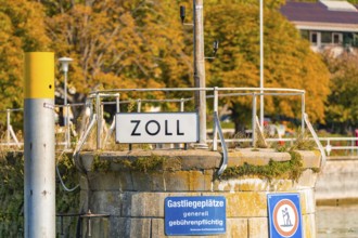 Small customs station on the shore with railings and signs in autumnal surroundings, Meersburg,