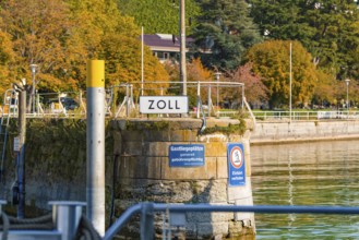Customs office in the harbour area surrounded by water and autumnal vegetation, Meersburg, Lake