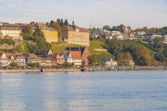 Houses along the lakeshore, surrounded by autumnal trees and hills, Meersburg, Lake Constance,