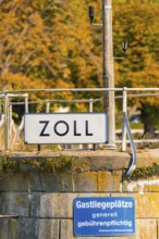 Close-up of a customs sign with autumn leaves in the background, Meersburg, Lake Constance, Germany