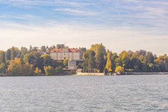 Sweeping view of the castle and autumnal forest by the lake, Mainau Island, Lake Constance, Germany
