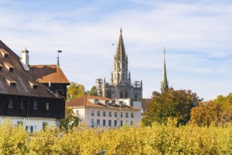 Historic church towers and buildings surrounded by autumn leaves under a clear sky, Constance, Lake