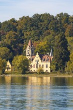 A historic manor house nestled in autumnal trees on the shore of a tranquil lake, Constance, Lake