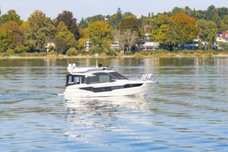 Luxurious white yacht sails on a calm lake surrounded by autumnal trees, Constance, Lake Constance,
