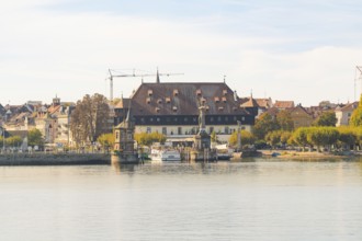 Historic riverside building with autumnal trees and peaceful atmosphere, Constance, Lake Constance,
