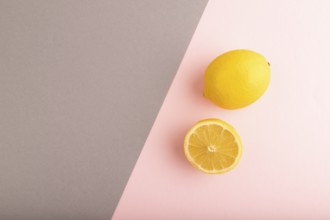 Yellow Lemon Cut in half on gray and pink pastel paper background. Top view, flat lay, copy space.