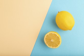 Yellow Lemon Cut in half on orange and blue pastel paper background. Top view, flat lay, copy space