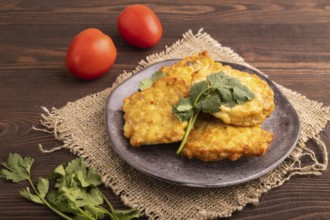 Fried crispy Chicken pancakes on brown wooden background and linen textile. side view, close up