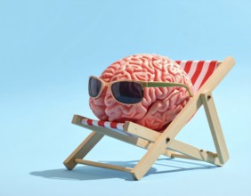 Brain relaxes on a sunbed under the summer sun, placed on a flat surface, symbol for mental health,