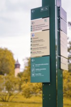 Signpost with various information in a park against an autumnal background, Mainau Island, Lake