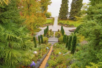 Well-tended garden with steps, lined with flowering plants in autumnal colours, Mainau Island, Lake
