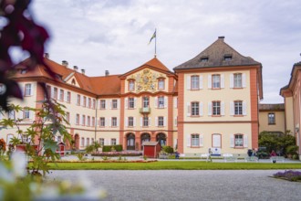 Large castle with architectural details, surrounded by a well-tended garden and visitors, Mainau