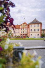 Historic castle building with manicured garden and blooming flowers in the foreground, Mainau