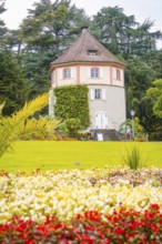 Round tower in the garden, surrounded by blooming flowers, Mainau flower island, Lake Constance,