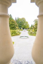 View of manicured path with fountain through decorative columns, Mainau flower island, Lake