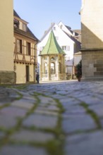 A quiet, narrow alley with cobblestones and historic buildings under a blue sky, Überlingen, Lake